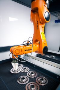 Der Kleinroboter greift die ungeordneten Kupplungsscheiben aus dem Drahtkorb und legt sie exakt in die Honmaschine. (Bild: Kuka Roboter GmbH)