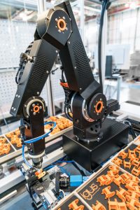 Ein Robolink-Gelenkroboter und ein Igus-Portalroboter montieren im Zusammenspiel Energieketten in der hauseigenen Fabrik in Köln. (Bild: igus GmbH)