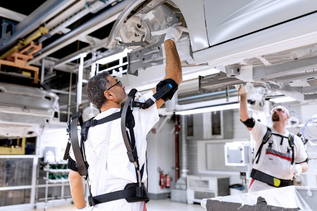 Audi is testing exoskeletons for performing overhead tasks. These external support structures help employees by protecting their joints and tiring their muscles less quickly. Employees in the paint shop are testing the exoskeletons while applying corrosio (Bild: Audi AG)