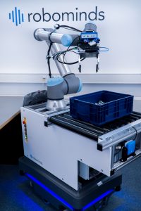 Mithilfe einer fahrenden Plattform wird der Pick-Roboter von Robominds mobil. KÃ¼nstliche Intelligenz hilft ihm bei der Erkennung von WerkstÃ¼cken. (Bild: RoboMinds GmbH)